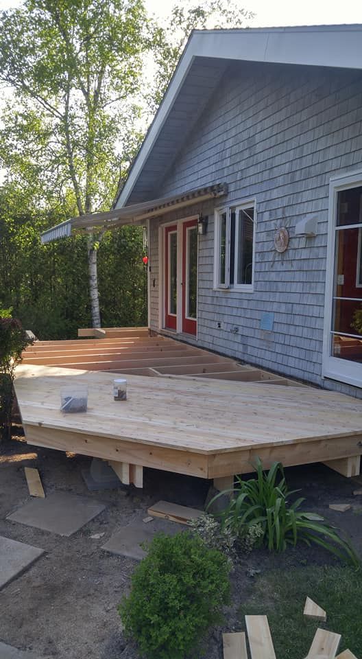 Cedar deck under construction showing joists and angled corner framing, Moncton NB
