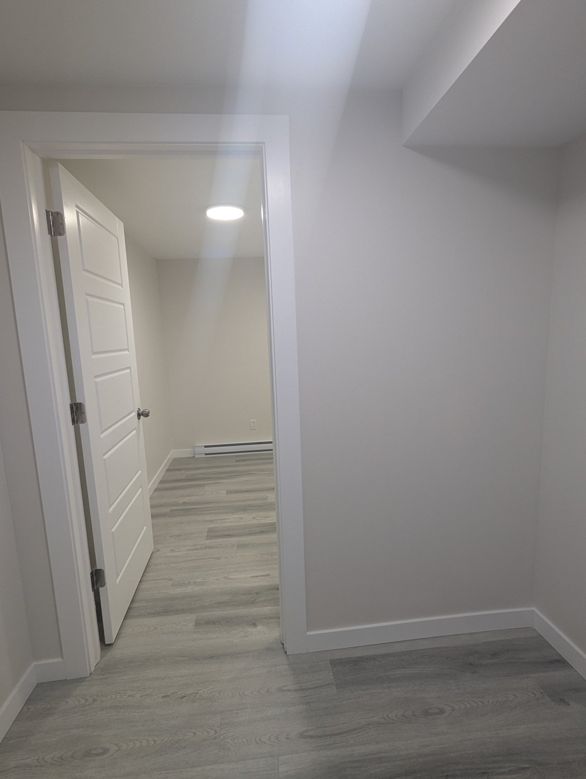 Finished hallway with baseboards, door casing and plank flooring by Valhalla Construction, Dieppe NB