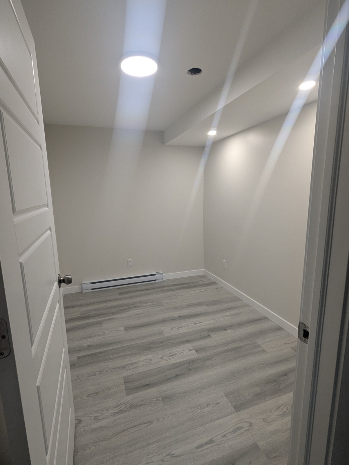 Finished basement room with pot lights, wainscoting and plank flooring by Valhalla Construction in Dieppe, NB