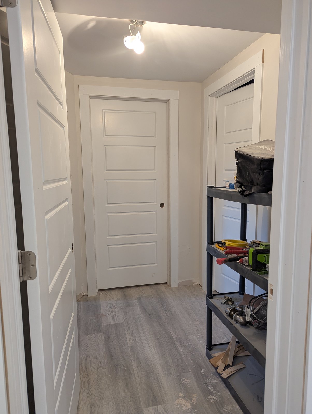 New plank flooring and door trim being installed in a basement hallway, Dieppe NB
