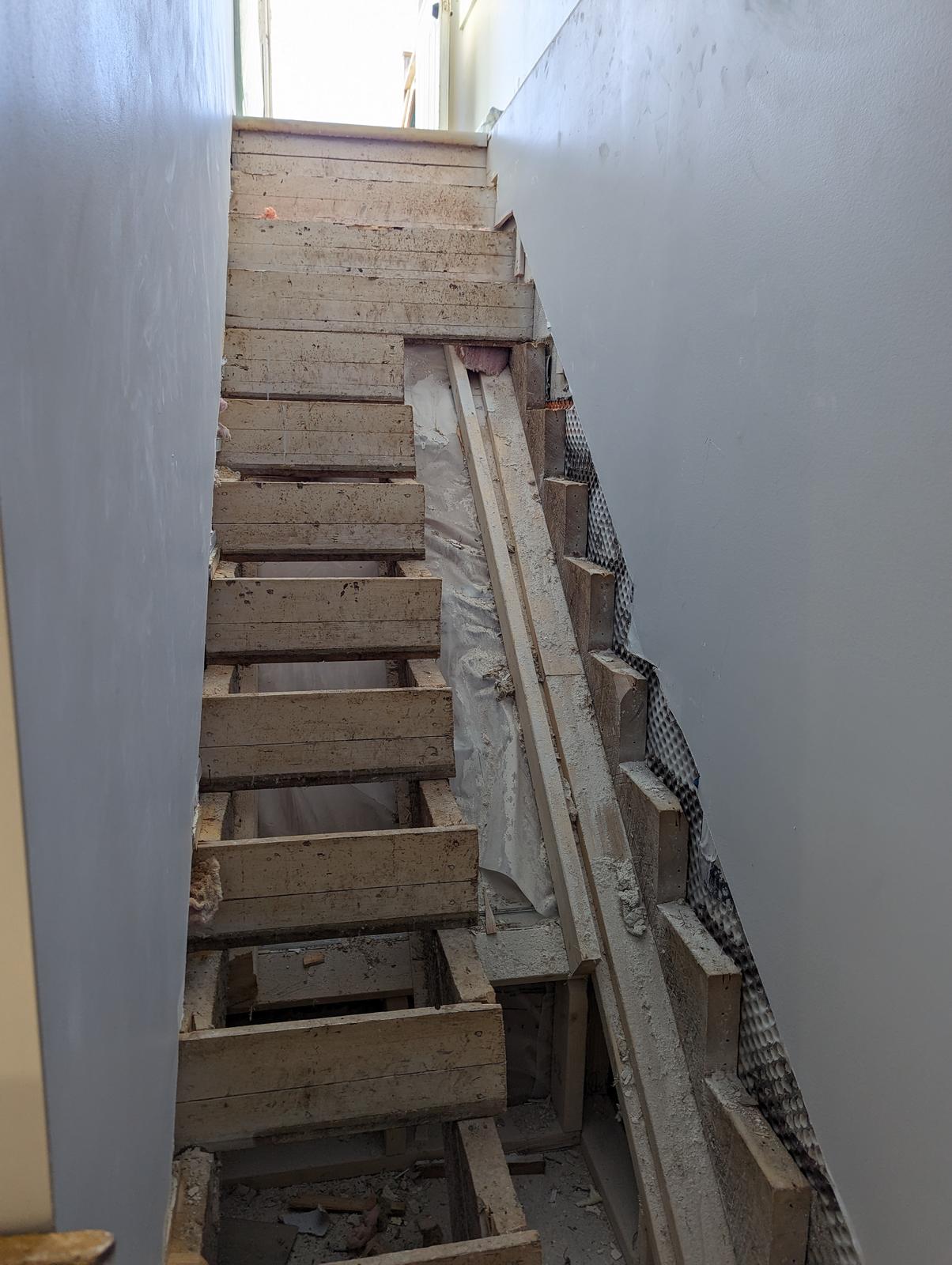 Basement stairs stripped back to stringers during rebuild, Riverview NB