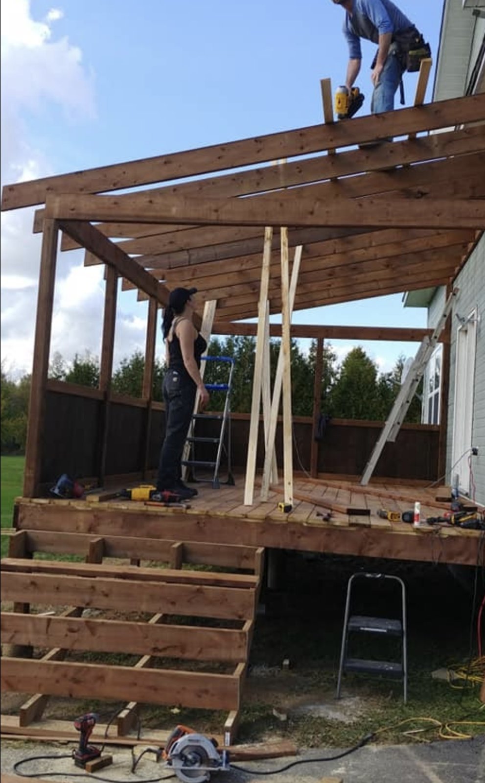 Crew framing the roof structure over a covered deck build