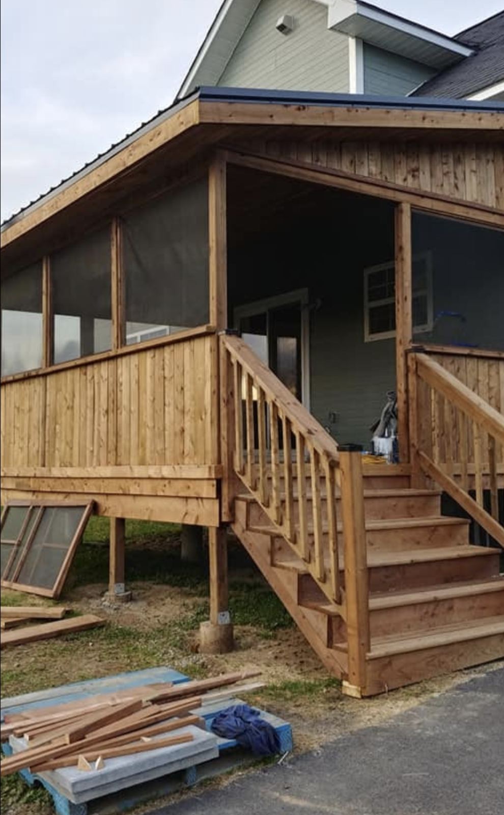 Screened covered deck with railings and stairs nearing completion