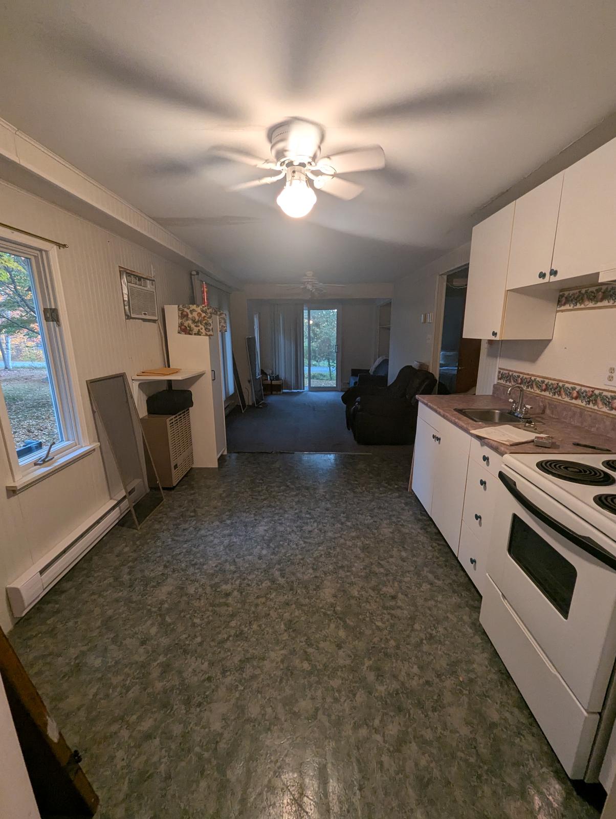 Dated vinyl kitchen and living room flooring before renovation