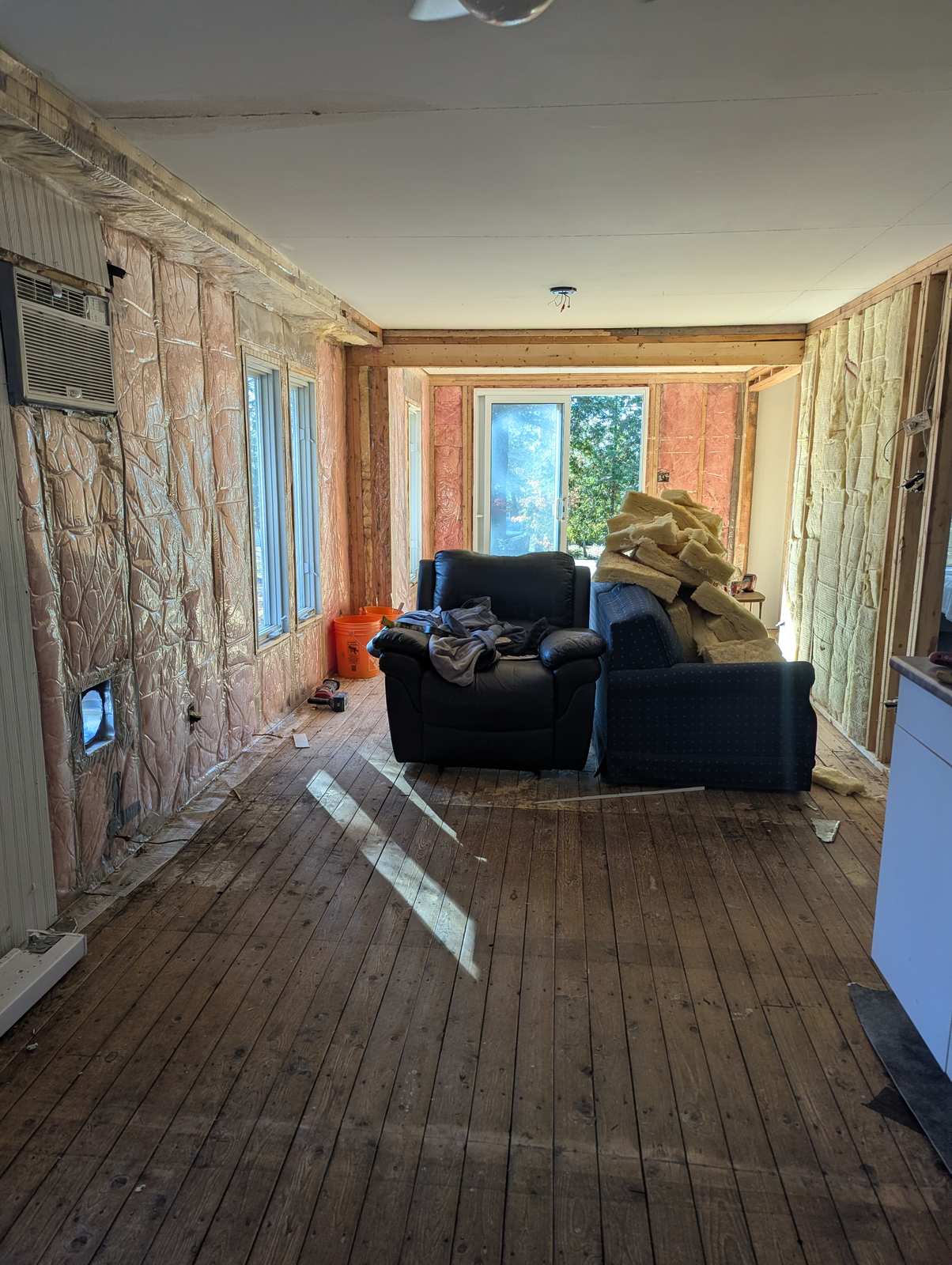 Original hardwood subfloor and exposed wall insulation during demolition