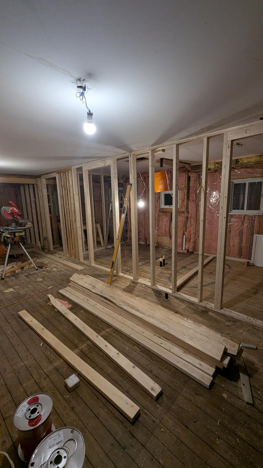 New stud framing over original hardwood subfloor during a flooring and trim renovation