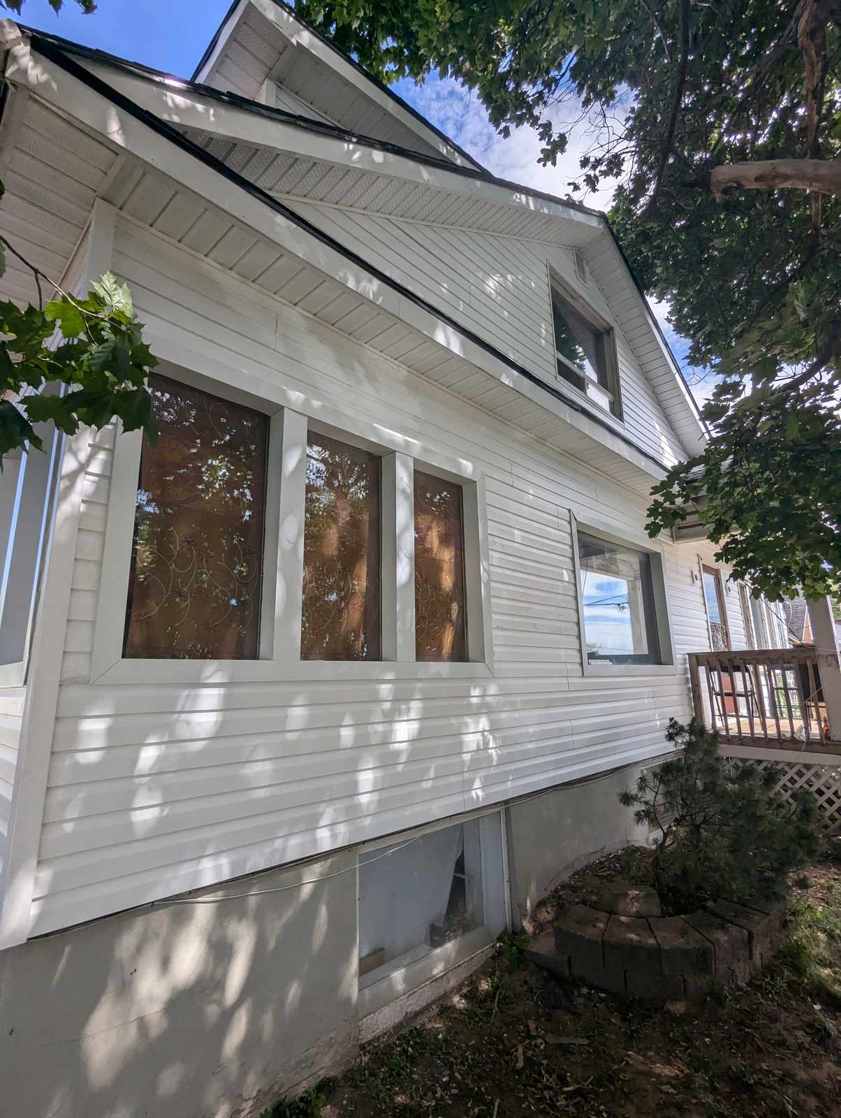 Finished white vinyl siding around a dormer window in Dieppe, NB