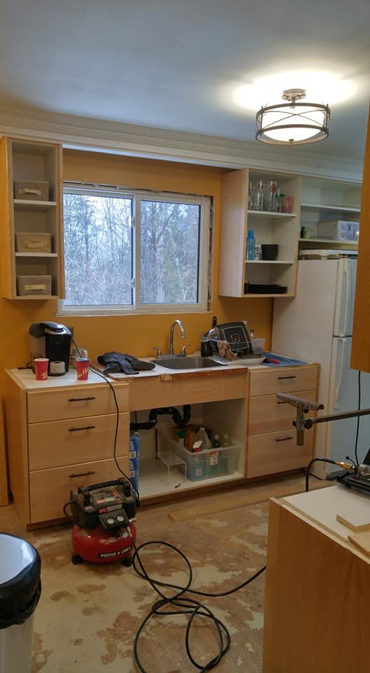Kitchen sink wall after renovation with honey oak cabinetry by Valhalla Construction