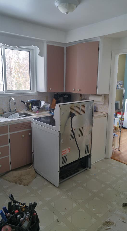 Kitchen sink wall before renovation, dated pink cabinetry