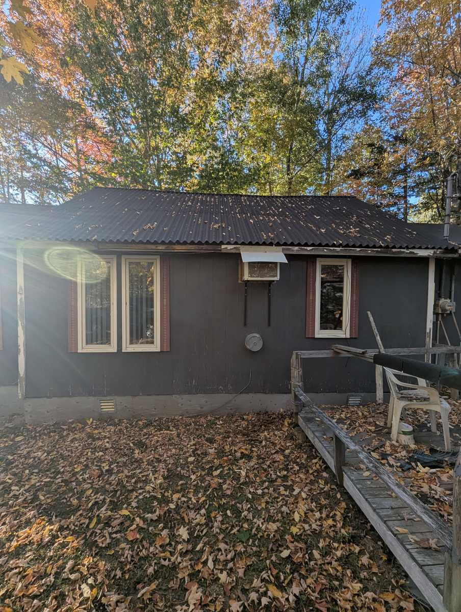 Weathered dark board siding before replacement